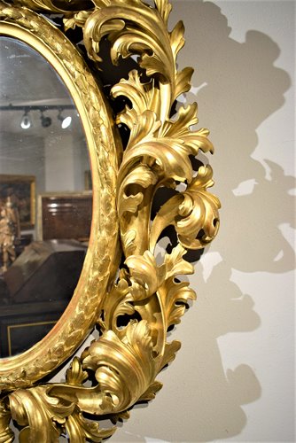 Grande specchiera ovale scolpita e dorata